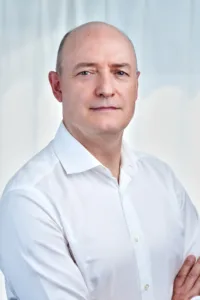 A corporate portrait of a businessman in a white shirt, taken in a professional photography studio in Tokyo.