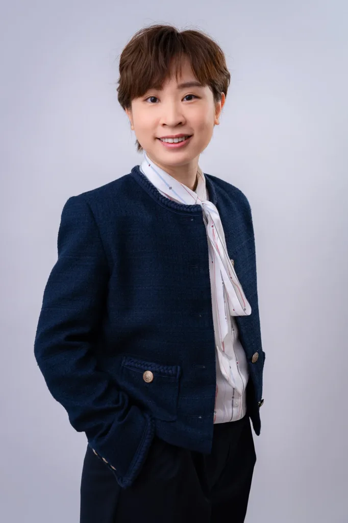 身穿藏青色西装外套与丝巾的女性企业形象照，由 JG Studio 在东京涩谷以影室闪光灯拍摄。
