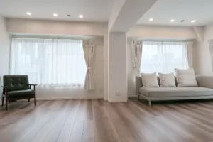 二つの大きな窓から光が差し込むJG Studioのワイドビュー。中央の柱を挟んでソファと椅子が配置された様子。