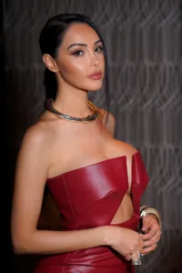 French influencer Nabilla posing in a stylish red dress with modern jewelry during a professional fashion photoshoot.