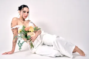 東京でのJGによるスタジオ・ポートレート撮影中、白いファッションの衣装で花束を持つ女性。