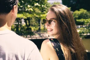 Lifestyle portrait of a smiling woman in aviator sunglasses during an outdoor shoot in Tokyo.
